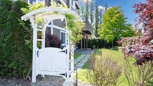 A residential property with a white gate, a covered walkway, and a well-maintained garden. - 2BR Hideaway: Bar Vibes, Game & LEGO Joy @Bellevue (Bellevue)