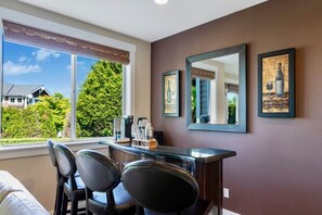 A room with a desk, two chairs, a window with blinds, and framed artwork on the wall. - 2BR Hideaway: Bar Vibes, Game & LEGO Joy @Bellevue (Bellevue)