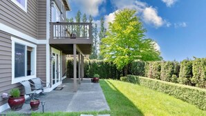 A residential property with a covered patio, outdoor seating, and a well-maintained lawn. - 2BR Hideaway: Bar Vibes, Game & LEGO Joy @Bellevue (Bellevue)