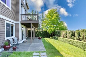 A residential property with a covered patio, outdoor seating, and a well-maintained lawn. - 2BR Hideaway: Bar Vibes, Game & LEGO Joy @Bellevue (Bellevue)