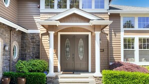 A two-story house with a central entrance, a stone facade on the left, and a brick exterior on the right. - Stylish Bellevue 5BR/2.5BA Upper Unit | LEGO Fun! (Bellevue)