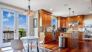 A modern kitchen with wooden cabinets, a stainless steel range hood, and a large island. - Stylish Bellevue 5BR/2.5BA Upper Unit | LEGO Fun! (Bellevue)