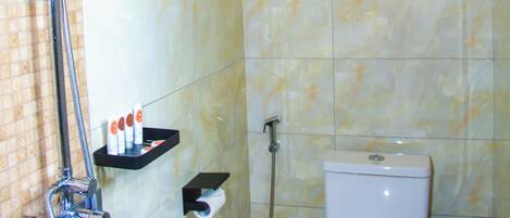 A bathroom with a shower, toilet, and a water heater.