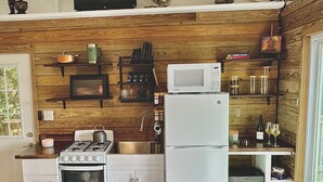 A compact kitchen with white appliances, wooden wall paneling, and a small window. - NEW LISTING! Your Private Paradise on St. John’s Beautiful Bordeaux Mountain (St John)