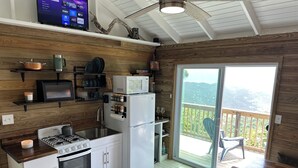 A modern kitchen with a gas stove, oven, and white refrigerator. There is a microwave, a sink, and a window overlooking a balcony with a view of the mountains. - NEW LISTING! Your Private Paradise on St. John’s Beautiful Bordeaux Mountain (St John)