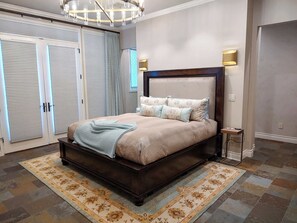 Ein Schlafzimmer mit einem großen Bett, einem Nachttisch, einer Pendelleuchte und einem Kleiderschrank mit Schiebetüren.