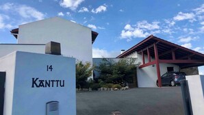 A building with a white facade and a red roof, labeled with the number 14 and the name "KANTTU".