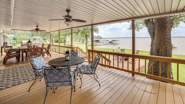 A covered outdoor deck with a table and chairs, overlooking a body of water. - Waterfront Retreat w/ Dock on Cedar Creek Lake! (Kemp)