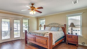 A bedroom with a wooden bed, a ceiling fan, and a nightstand with a lamp. - Waterfront Retreat w/ Dock on Cedar Creek Lake! (Kemp)