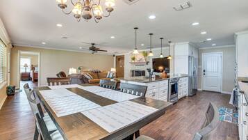 A spacious kitchen with a central island, pendant lighting, and a ceiling fan.