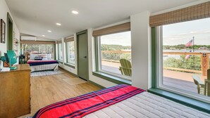 A bedroom with a large window, a bed, a desk, and a chair. - Lake View + Huge Deck: Cozy Possum Kingdom Retreat (Graham)