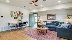 A living room with a blue sofa, a coffee table, and a patterned rug. - Lake View + Huge Deck: Cozy Possum Kingdom Retreat (Graham)
