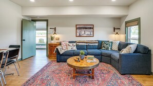 A living room with a blue sectional sofa, a round coffee table, and a patterned rug. - Lake View + Huge Deck: Cozy Possum Kingdom Retreat (Graham)