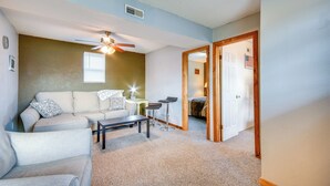 A living room with a ceiling fan, a sofa, a coffee table, and a small dining table. - 1 Mi to Mark Twain Lake: Cabin w/ Community Pool (Stoutsville)