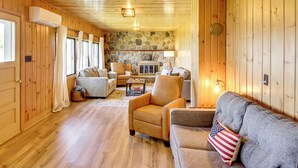 A cozy cabin interior with wooden walls, a stone fireplace, and a comfortable seating area. - Hackensack Waterfront Retreat on Tenmile Lake (Hackensack)