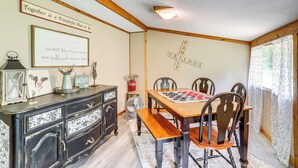 A dining room with a wooden table, four chairs, a bench, a dresser, and wall decorations including a sign and a framed quote. - < 1/2 Mi to Lake: Secluded Gem in Cherokee Village (Cherokee Village)