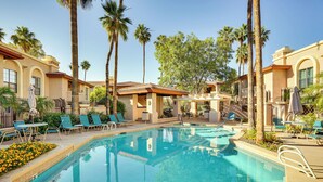 A pool area with lounge chairs, palm trees, and a clear blue pool. - Family-friendly Condo w/ Pool Access in Phoenix! (Phoenix)