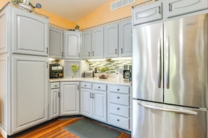 A kitchen with grey cabinets, a stainless steel refrigerator, and a tiled backsplash. - Hot Tub & Fire Pit: Rockbridge Getaway! (Rockbridge)