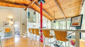 A modern kitchen with a wooden ceiling, a red column, and a bar area with four chairs. - Live Lake Life! Enchanted Oaks Gem w/ Private Dock (Mabank)