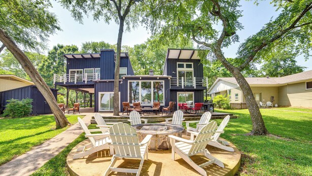A two-story house with a deck, outdoor seating area with chairs, and a fire pit. - Live Lake Life! Enchanted Oaks Gem w/ Private Dock (Mabank)