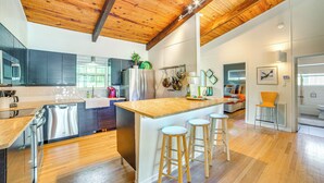 A modern kitchen with wooden beams, stainless steel appliances, and a central island with stools. - Live Lake Life! Enchanted Oaks Gem w/ Private Dock (Mabank)