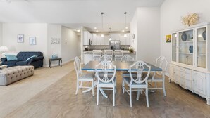 A spacious living area with a dining table and chairs, a sofa, and a cabinet with glass doors. - 10 Golden Eagle Dr, Ocean View, DE (Ocean View)