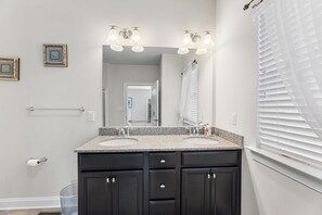 A bathroom with two sinks, a large mirror, and a window with blinds. - 10 Golden Eagle Dr, Ocean View, DE (Ocean View)
