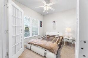 A bedroom with a bed, a nightstand, a lamp, a ceiling fan, and a window with blinds. - 10 Golden Eagle Dr, Ocean View, DE (Ocean View)