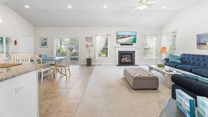 A spacious living room with a fireplace, a large TV mounted above it, and a comfortable seating area with a sofa and ottoman. - 10 Golden Eagle Dr, Ocean View, DE (Ocean View)