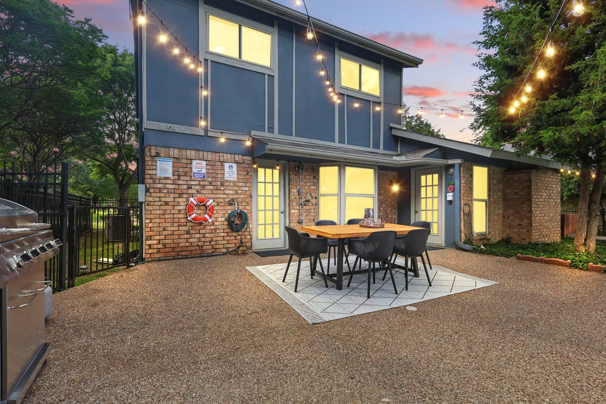A building with a brick exterior, a wooden deck, and a barbecue grill.