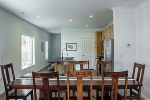 A dining area with a wooden table and chairs, a kitchen with wooden cabinets, and a view of the backyard through a window. - NEW LISTING | 3BR | 2.5 bath, Mountain Views, 1 Mile to downtown (Leadville)