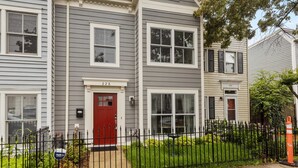 A two-story residential building with a red front door, numbered 228, and a black metal fence in front. - Classy Old Town Getaway, 3-BR in Perfect Location (Alexandria)