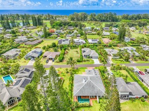A residential area with houses, a golf course, and a view of the ocean.