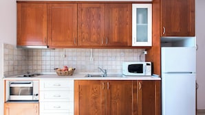 A kitchen with wooden cabinets, a microwave, a toaster, and a sink.