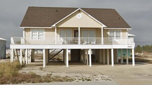 A two-story house with a balcony, a covered entryway, and a small porch. - Windsail 6 Bedroom Home (Navarre)