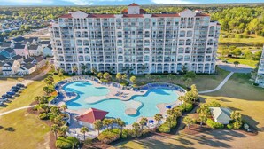 Un grand hôtel doté de nombreux balcons et d’une piscine centrale.