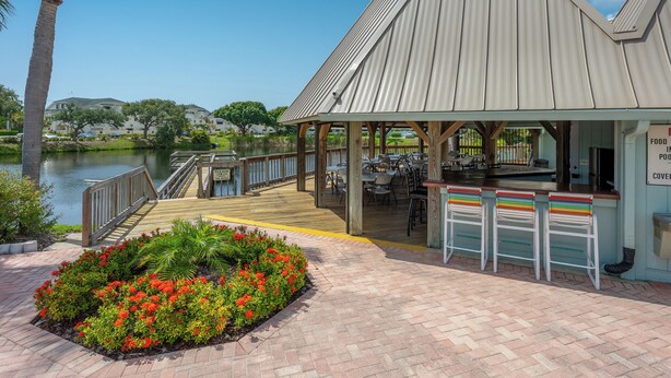 Ein Restaurant am Wasserufer mit Terrassenplätzen, einer Holzterrasse und Blick auf den See.