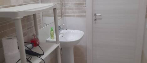 A bathroom with a white sink, a mirror, and a towel rack.