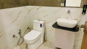 A bathroom with a toilet, bidet, and sink. - Hotel Shree Rameshwaram (Khandwa)