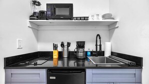 A compact kitchen with a black countertop, a dishwasher, and a coffee maker. - Cozy Studio in Miami Near Wynwood Prime Location (Miami)