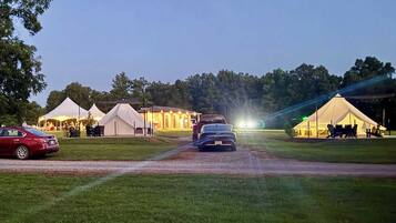 A campsite with tents and a car parked on a dirt path.