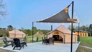Un espacio al aire libre con carpas, con un letrero que dice "BLACK WALNUT". Se aprecia un patio con sillas y una mesa, y un edificio al fondo.