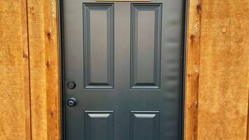 A black door with a sign reading "BLACK WALNUT" above it, framed by wooden panels.