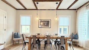 A dining area with a wooden table and chairs, a ceiling with exposed beams, and a framed picture on the wall. - Downtown Ludlow, walk to ski shuttle, room for multiple families, pet friendly! (Ludlow)