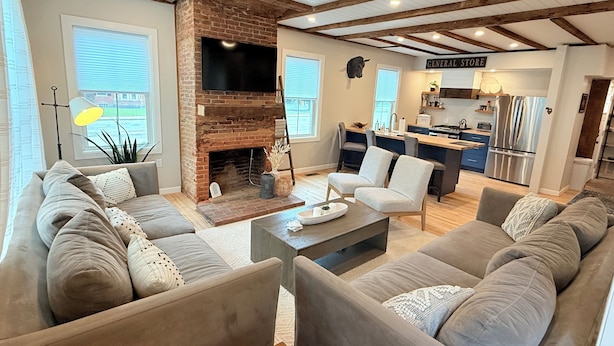 A spacious living room with a fireplace, a kitchen area, and a dining space. - Downtown Ludlow, walk to ski shuttle, room for multiple families, pet friendly! (Ludlow)