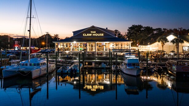 A waterfront restaurant named "The Claw House" with a docked boat in front.