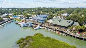 A marina with boats docked, a restaurant, and a building with a green roof.
