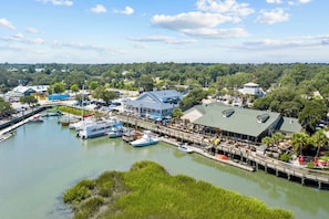A marina with boats docked, a restaurant, and a building with a green roof. - High Tides, Good Vibes Resort Pool By Beach Star (Murrells Inlet)