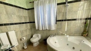 Un baño con bañera, inodoro y ducha.
