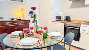 Une cuisine moderne avec des meubles blancs, un four à micro-ondes et un four traditionnel.